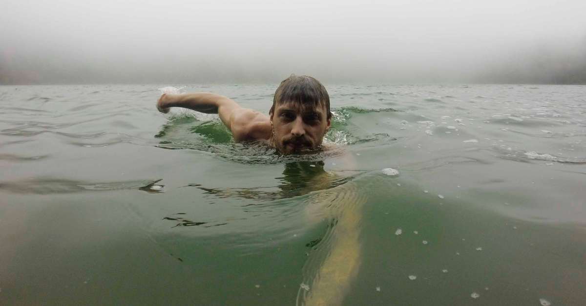 seorang pria berenang di tengah laut dan mendung badai (arti mimpi berenang)
